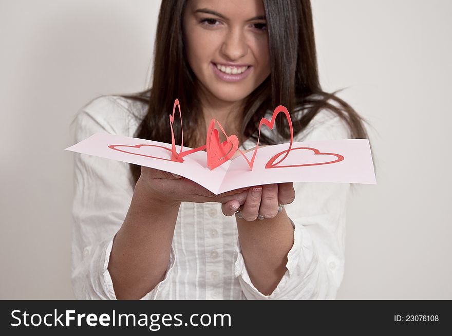 Young girl with card with pop up hearts