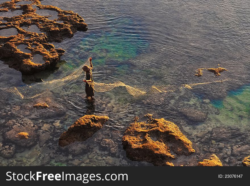 Fisherman At The Sea Coast With Fishing Net