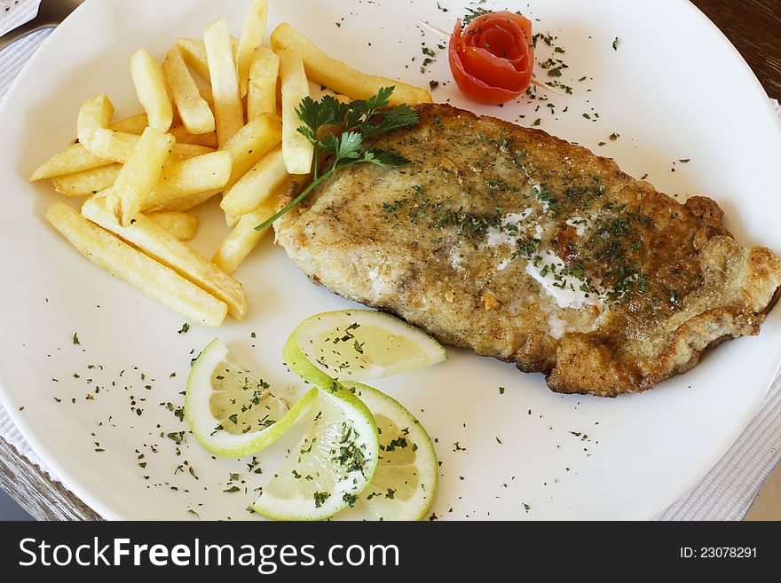 Gourmet restaurant fried hake fish in batter and chips on a white plate. Gourmet restaurant fried hake fish in batter and chips on a white plate