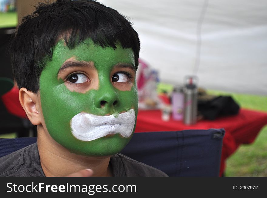 A cute little boy has a frightened expression in his painted face. A cute little boy has a frightened expression in his painted face.
