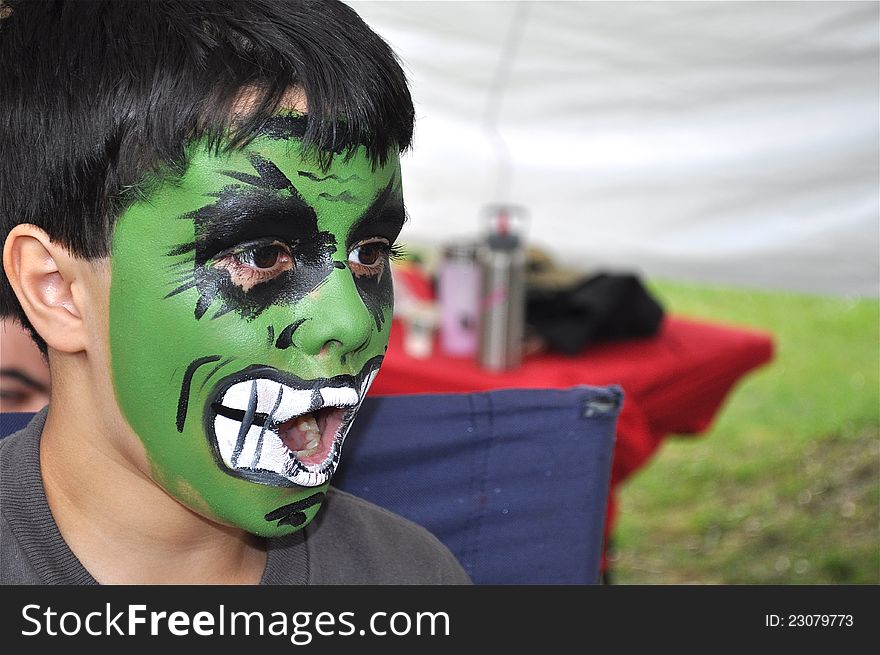 A nice little boy is being shocked. His green painted face has a surprised expression. A nice little boy is being shocked. His green painted face has a surprised expression.