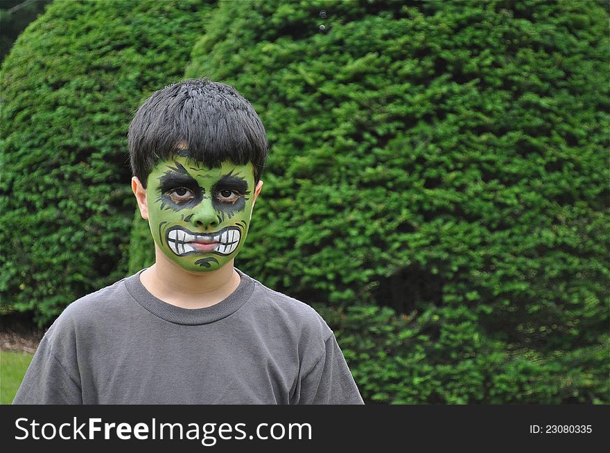 A young kid with a painted face is looking to the camera, mad or sad. A young kid with a painted face is looking to the camera, mad or sad.