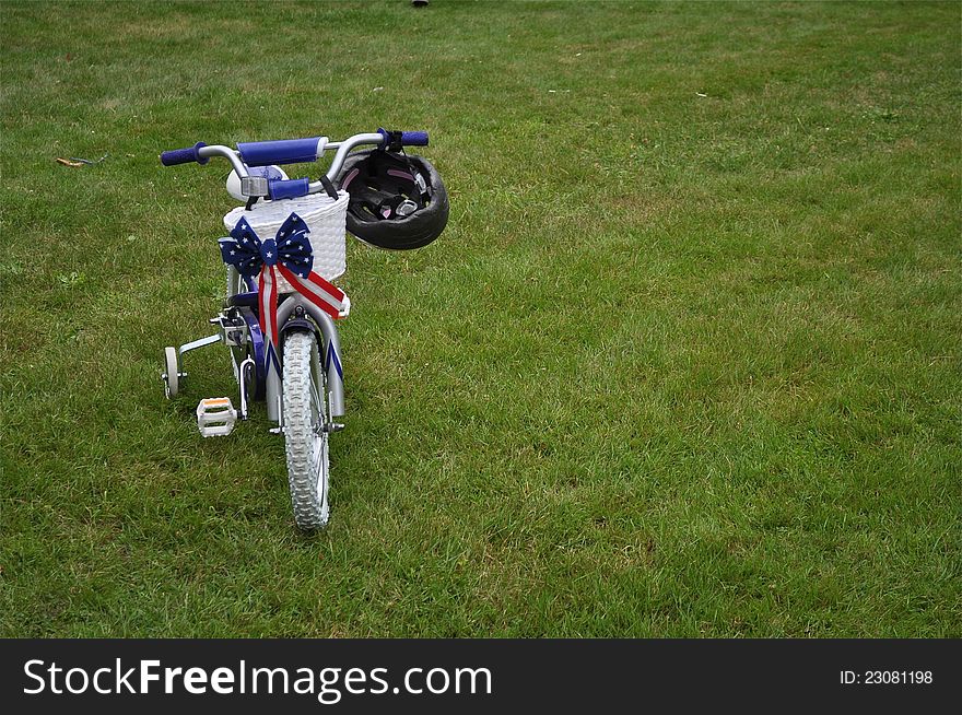 A tricycle is on grass, waiting for its little owner. A tricycle is on grass, waiting for its little owner.