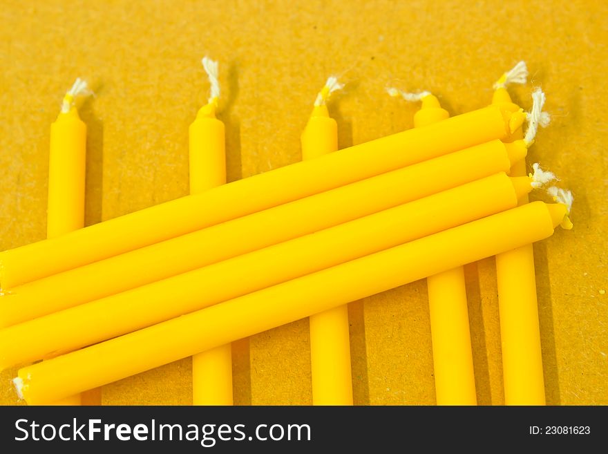 Small yellow candles  on background. Small yellow candles  on background
