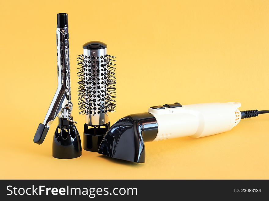 Hairdressing set with various accessories on yellow background