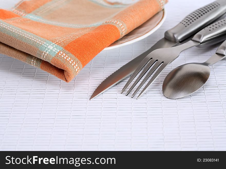 Closeup of cover set near checkered napkin on plate. Closeup of cover set near checkered napkin on plate