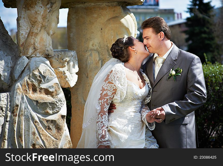 Happy bride and groom about ancient column