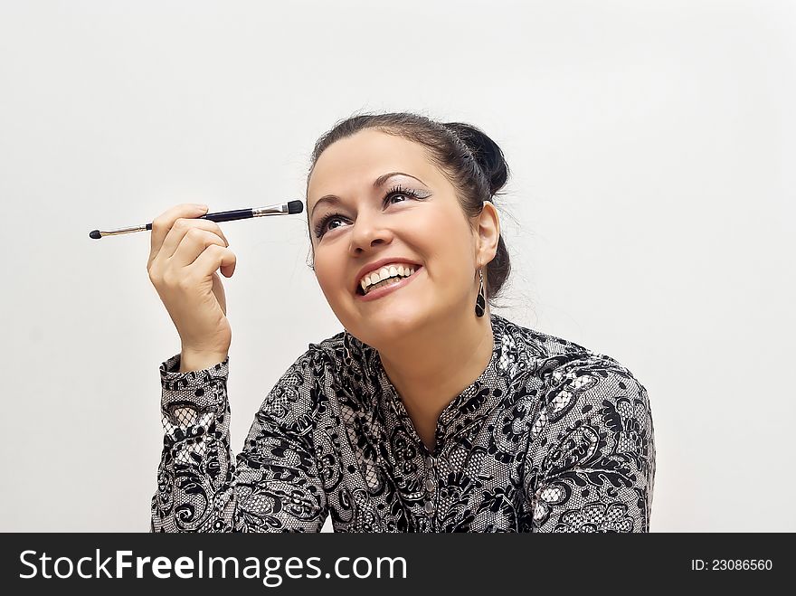 Beautiful girl looks up with make-up on a grey background