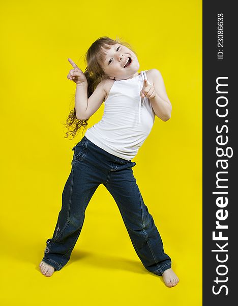Cheerful girl dances on a yellow background. Cheerful girl dances on a yellow background