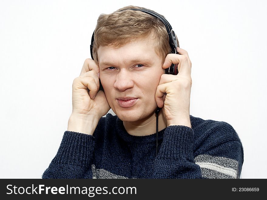 Expression guy listening to music on headphones on a grey background. Expression guy listening to music on headphones on a grey background