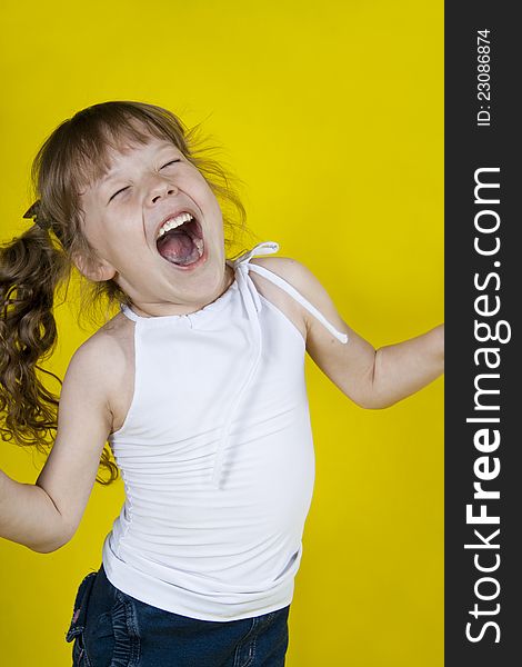 Cheerful Girl Dances On A Yellow Background
