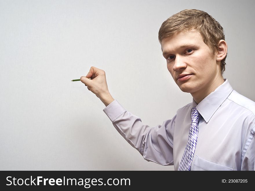 On a gray background business guy holding a pencil