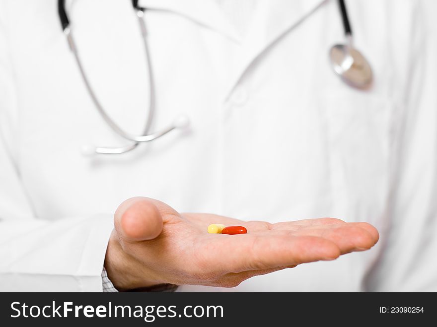 Male doctor showing a pill on his palm. Male doctor showing a pill on his palm