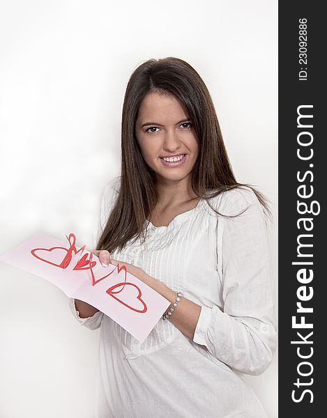 Young girl photographed on white background with card with pop up hearts for the  Valentines day. Young girl photographed on white background with card with pop up hearts for the  Valentines day