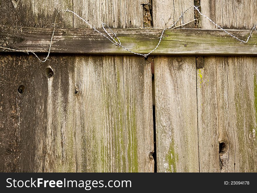 Exterior wood fence with barbed wire.