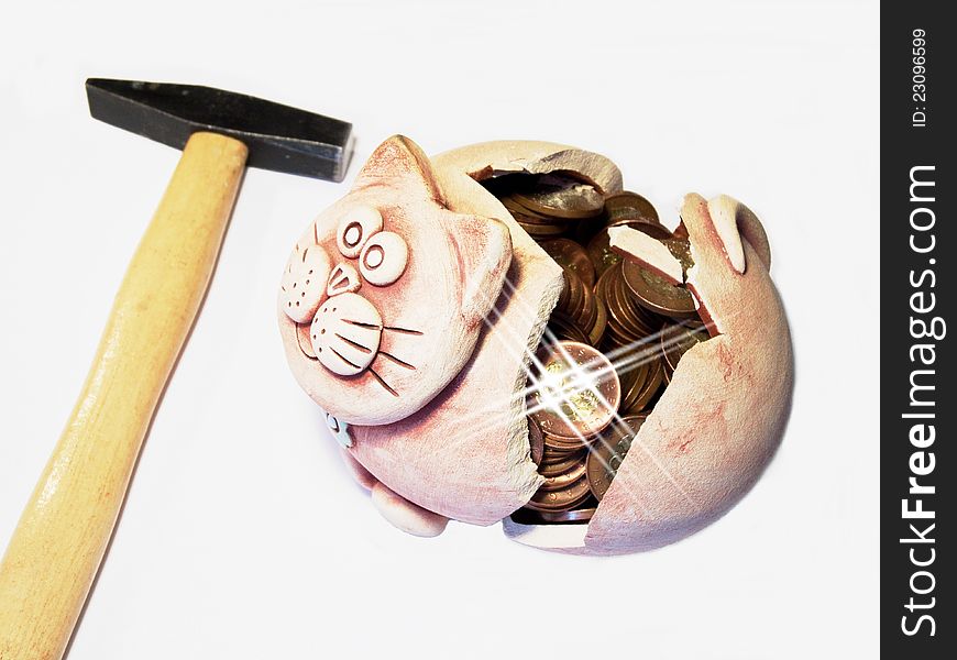 Hammer smashed moneybox in the shape of a cat on a coin. Hammer smashed moneybox in the shape of a cat on a coin.