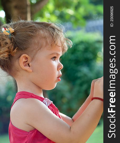 Profile of cute girl looking at it in the park