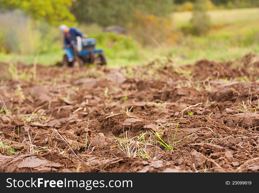 Tractor Ploughing on the Field. Autumn. Shallow depth of field. Focus on foreground.