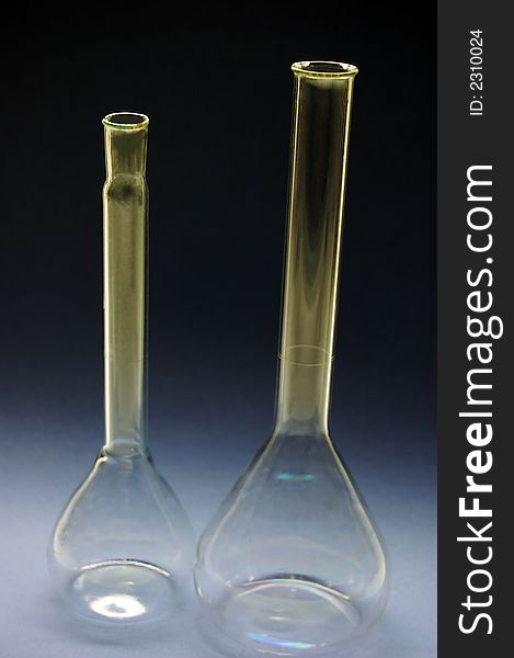 Two chemical tall flasks in a dark background. Two chemical tall flasks in a dark background