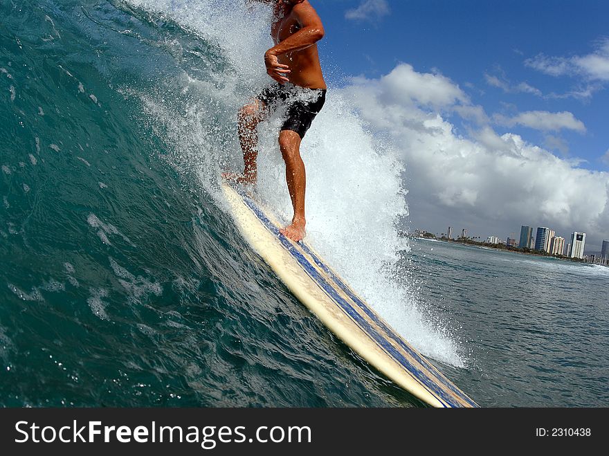 A longboard surfer taking off on a wave
