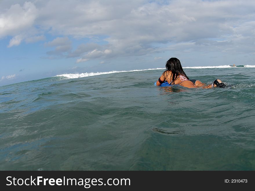 A bikini bodyboarder teen girl paddling out. A bikini bodyboarder teen girl paddling out