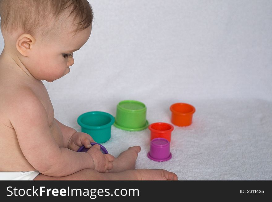 Image of adorable baby playing with stacking cups. Image of adorable baby playing with stacking cups