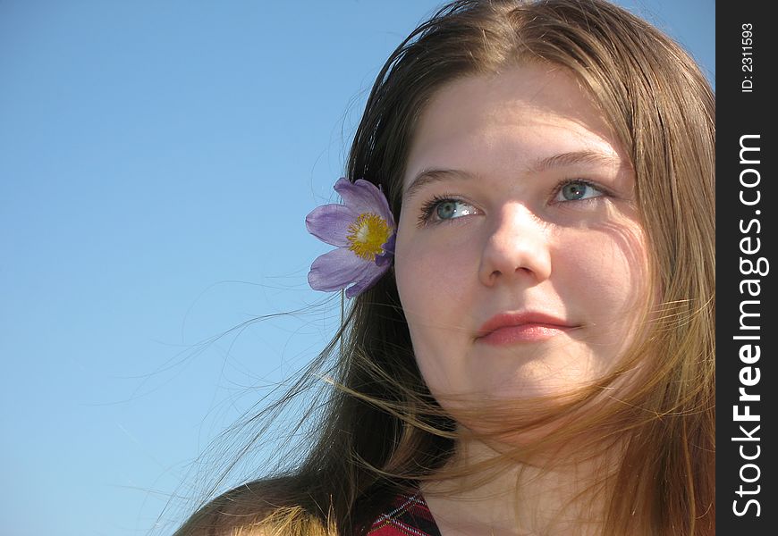 Pretty young girl with the flower in the hair