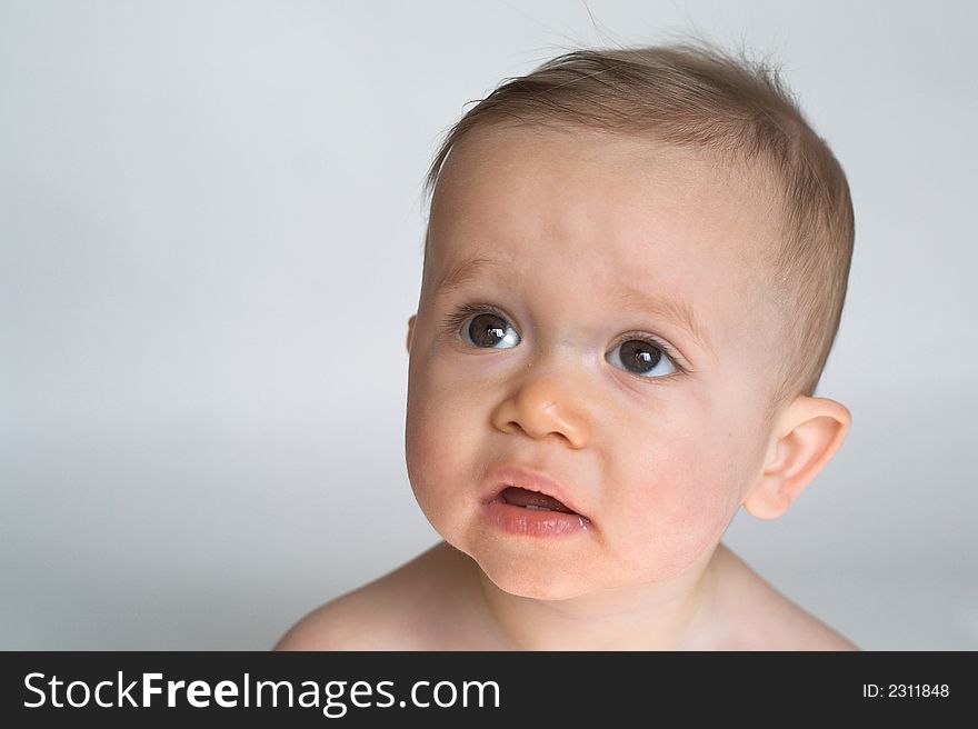 Image of beautiful 10 month old baby boy  sitting in front of a white background. Image of beautiful 10 month old baby boy  sitting in front of a white background