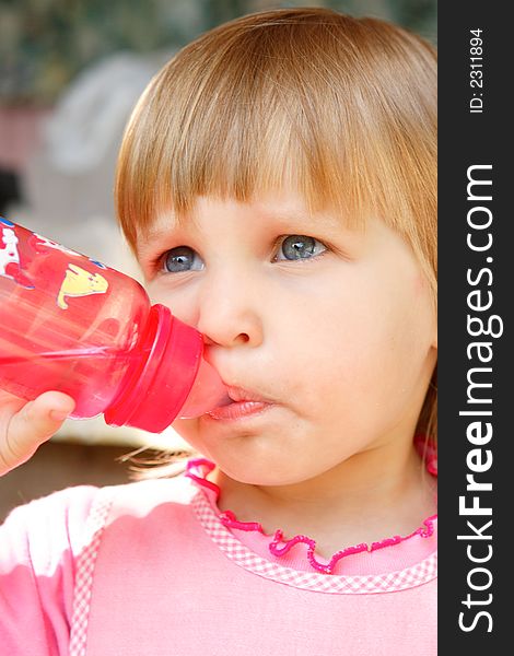 The girl drinks water from a bottle