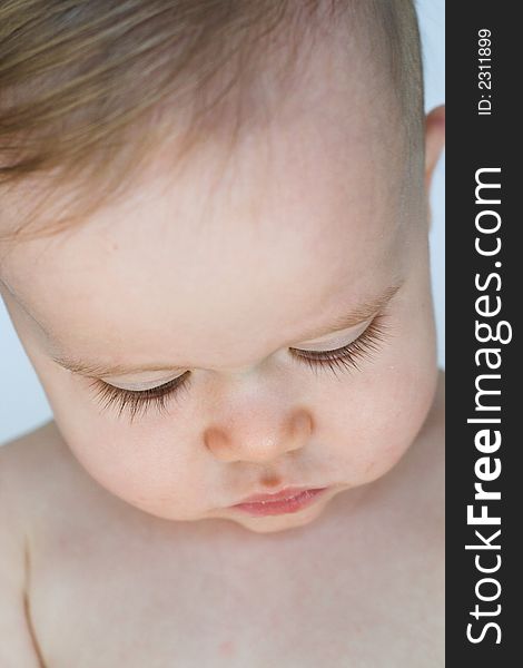 Image of a beautiful baby looking down so his eyelashes are visible. Image of a beautiful baby looking down so his eyelashes are visible