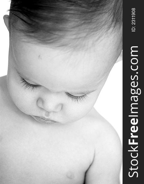 Black and white image of a beautiful baby looking down so his eyelashes are visible. Black and white image of a beautiful baby looking down so his eyelashes are visible