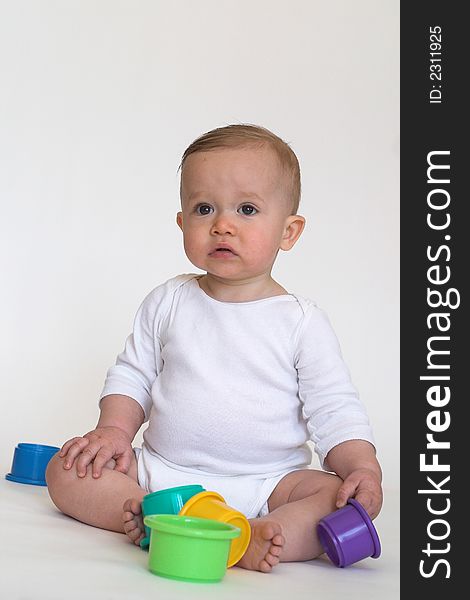 Image of adorable baby playing with stacking cups. Image of adorable baby playing with stacking cups