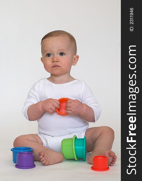 Image of adorable baby playing with stacking cups. Image of adorable baby playing with stacking cups