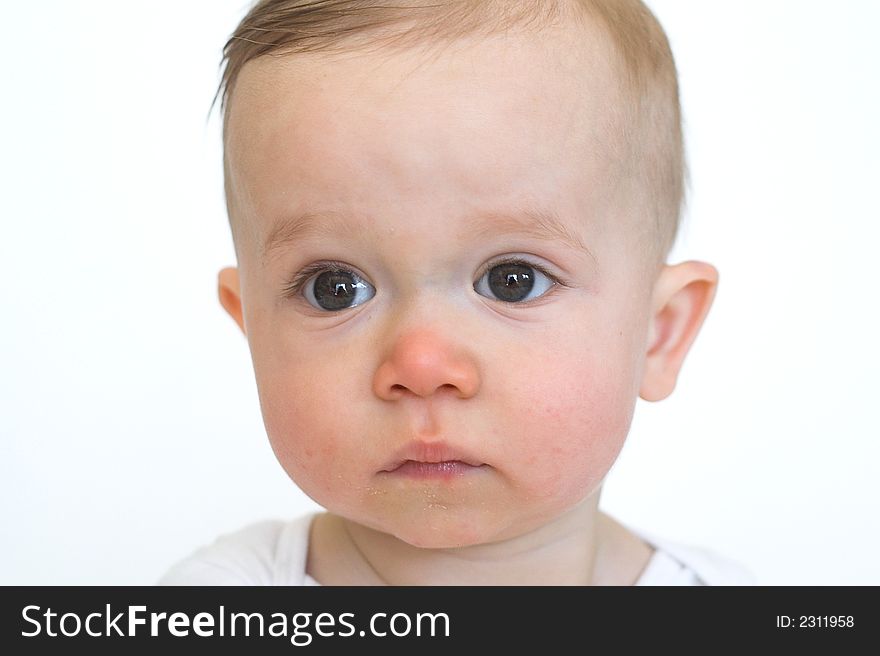 Image of beautiful 10 month old baby boy wearing a white shirt, sitting in front of a white background. Image of beautiful 10 month old baby boy wearing a white shirt, sitting in front of a white background