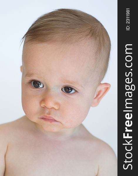 Image of beautiful 11 month old baby boy  sitting in front of a white background. Image of beautiful 11 month old baby boy  sitting in front of a white background