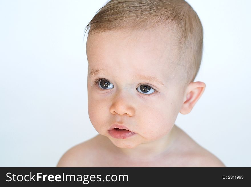 Image of beautiful 11 month old baby boy  sitting in front of a white background. Image of beautiful 11 month old baby boy  sitting in front of a white background