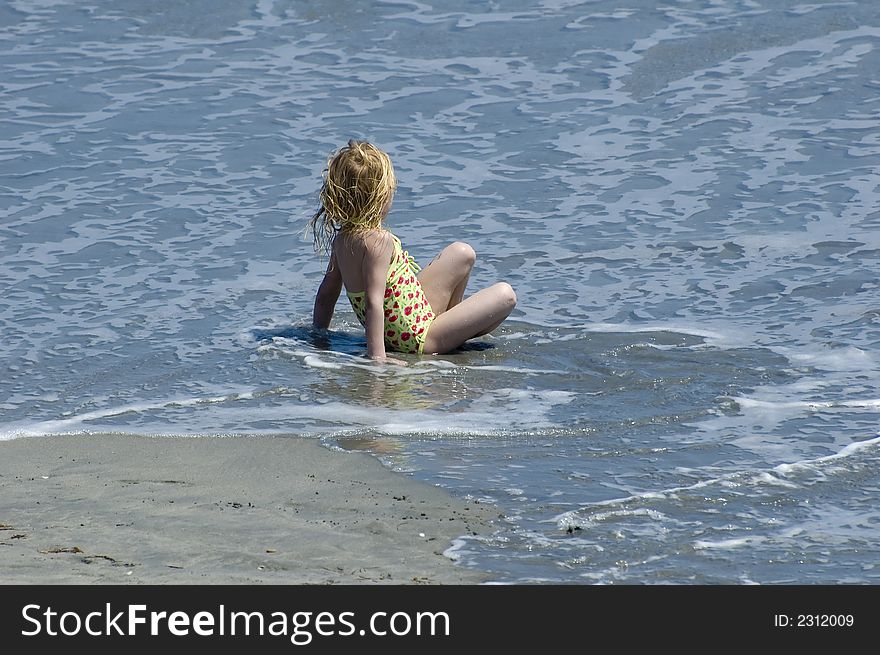 Young girl relaxing in the surf on a sunny day in Florida. Young girl relaxing in the surf on a sunny day in Florida