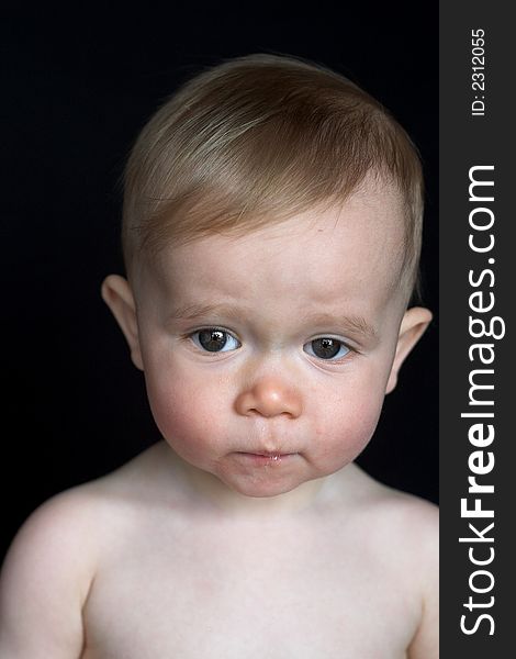 Image of beautiful baby sitting in front of a black background