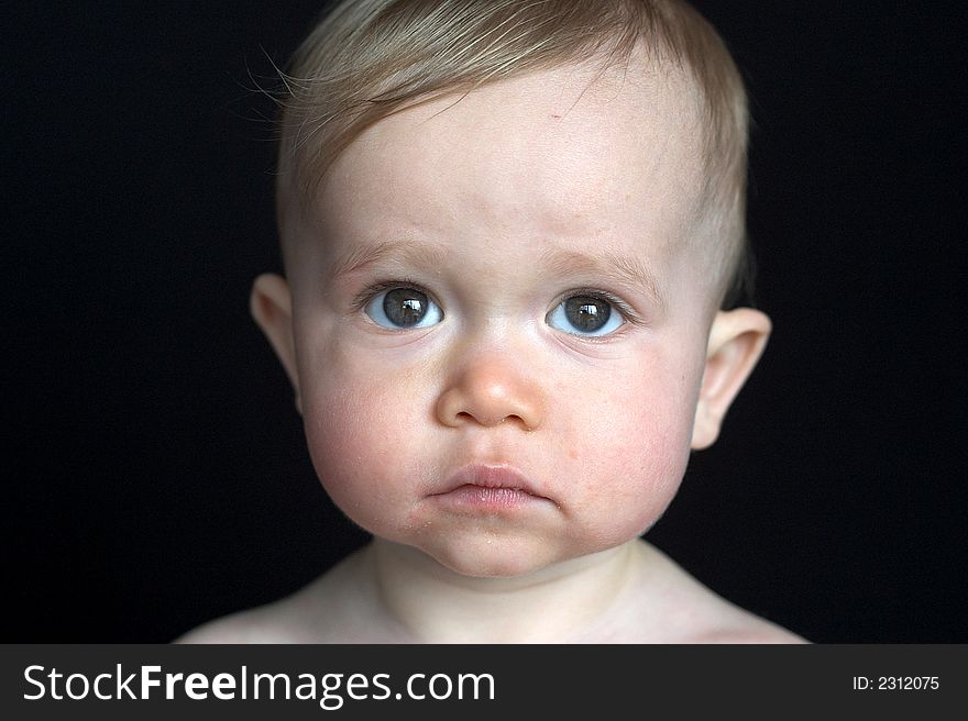 Image of beautiful baby sitting in front of a black background
