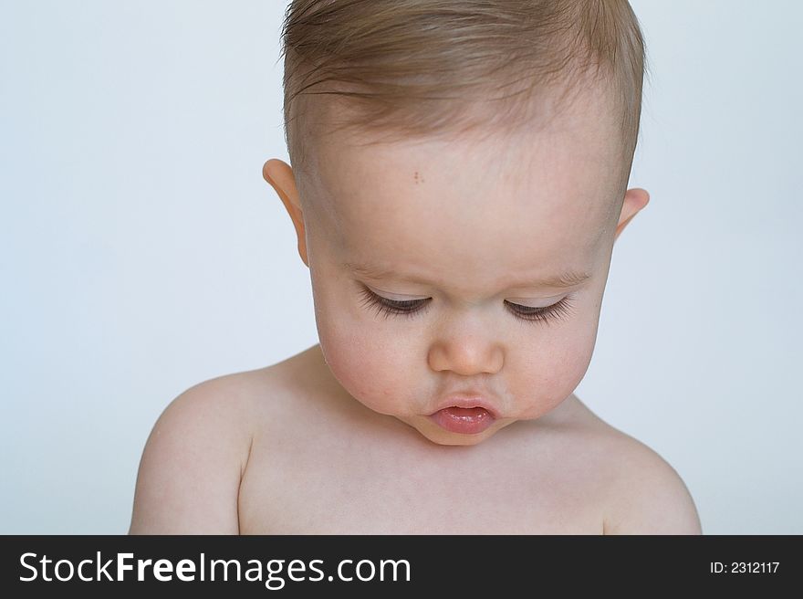 Image of beautiful 11 month old baby boy sitting in front of a white background. Image of beautiful 11 month old baby boy sitting in front of a white background