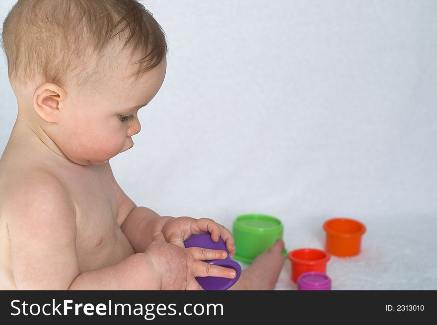 Image of adorable baby playing with stacking cups. Image of adorable baby playing with stacking cups