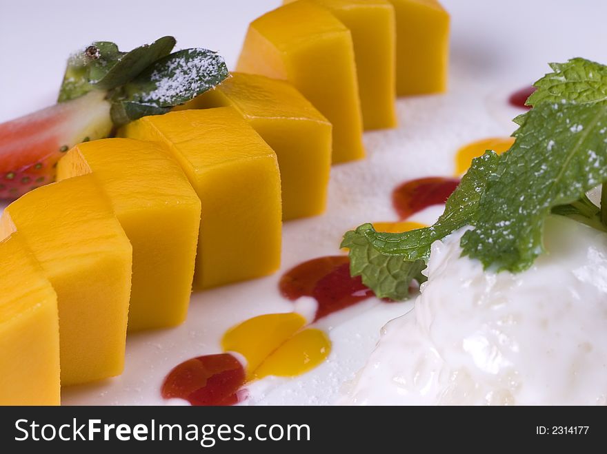 Color mango dessert decorated with strawberry and mint. Color mango dessert decorated with strawberry and mint