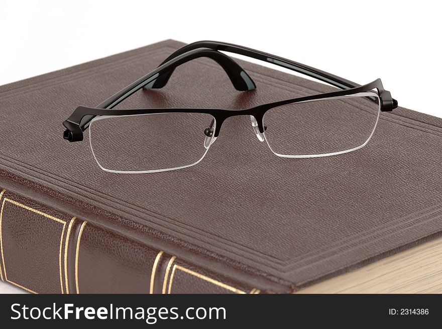 Eyeglasses and a brown book on a white background. Eyeglasses and a brown book on a white background.