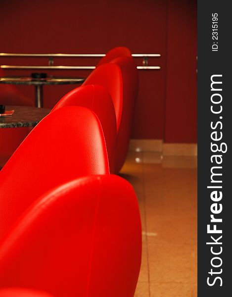 Interior of modern restaurant. Red leather and luxury chairs.