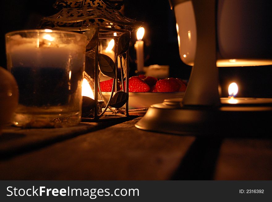 Stawberries on a talbe light by several candles. Stawberries on a talbe light by several candles