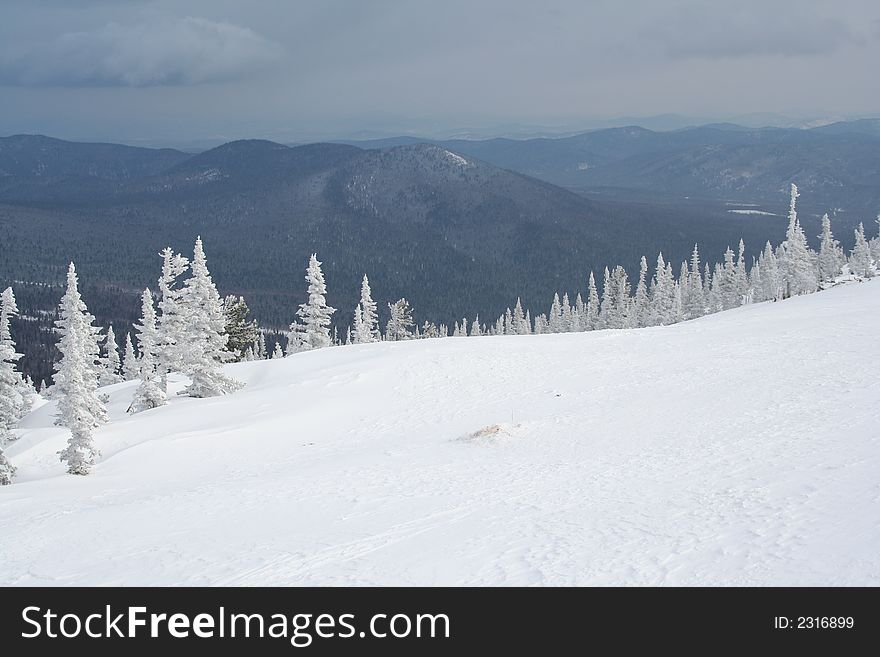 A view of blue mountains from a snow-covered alp