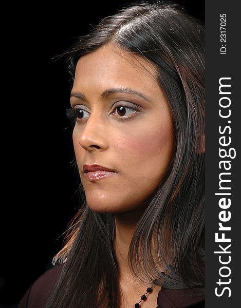 Profile of indian girl lookind left against a black background