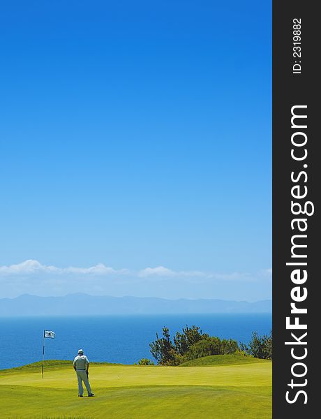 A man golfing with catalina island in the background