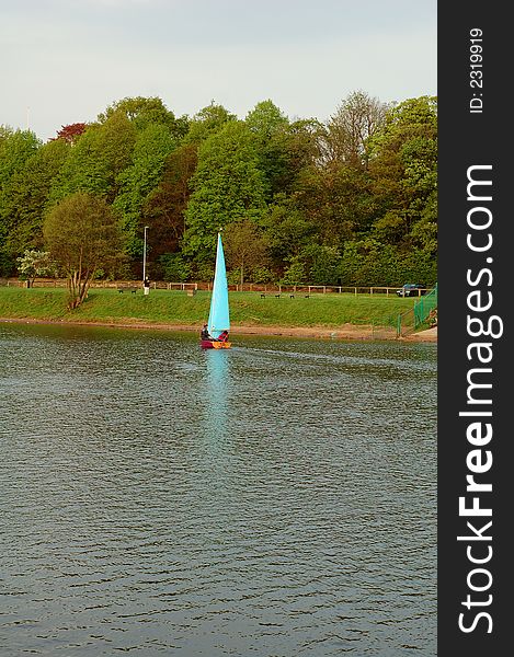 Boats sailing on a lake or river with the sails catching the wind. Boats sailing on a lake or river with the sails catching the wind