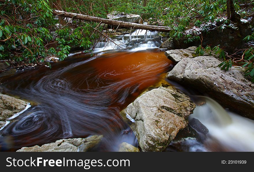 Natural tannin colored stream and waterfalls in the mountains in winter. Natural tannin colored stream and waterfalls in the mountains in winter